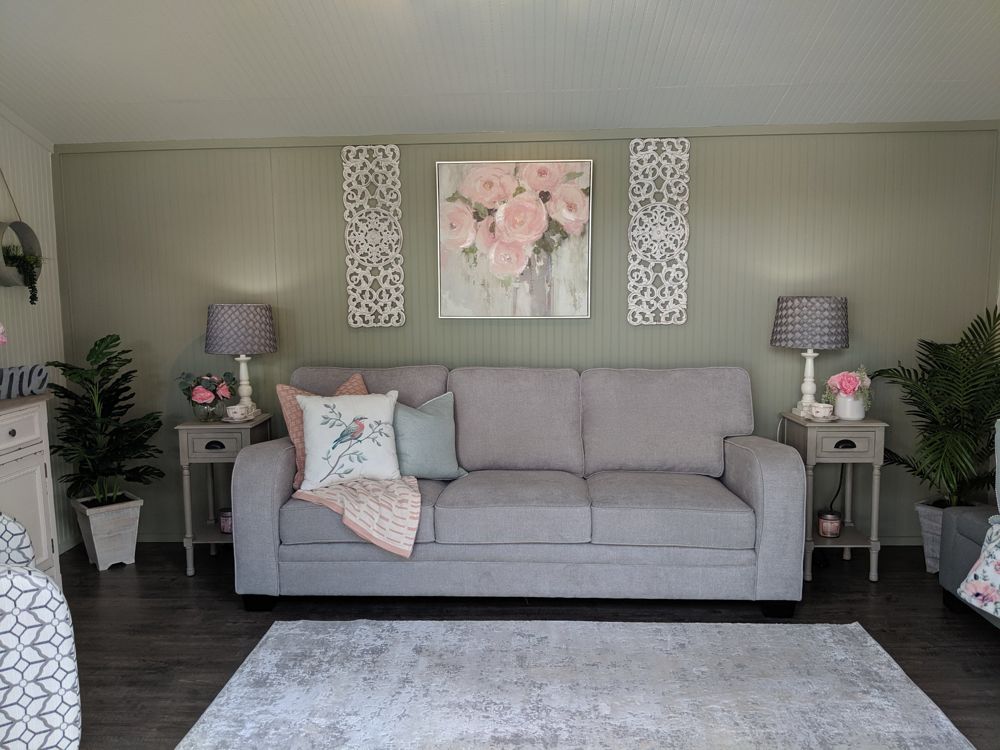 Finished studio set up as a sitting room with sofa, lamps and artwork